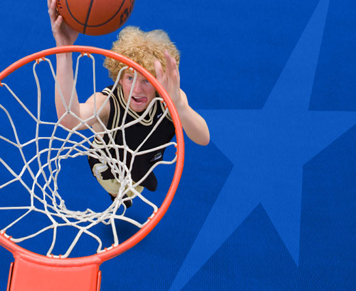 Teen dunking basketball on a DunkStar Couurt