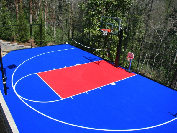 Backyard basketball half court in bright blue and red