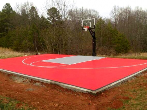 3/4 View of bright red basketball half court with gray key