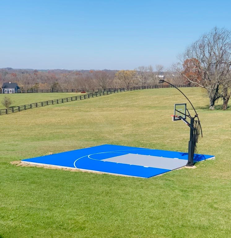 Bright blue and gray basketball court in field