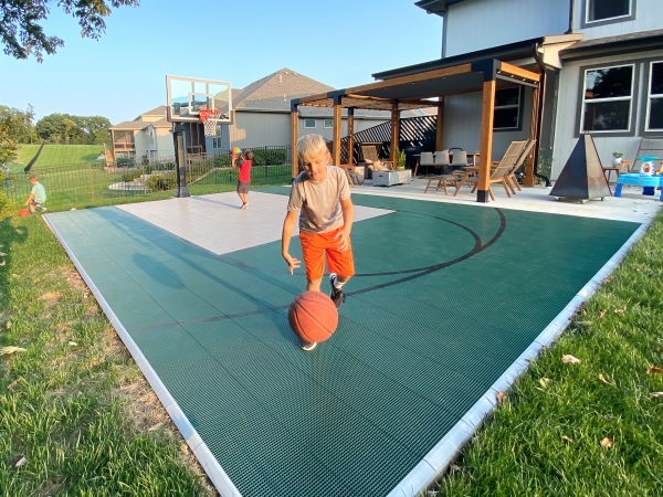 Boys playing basketball on evergreen and gray half court