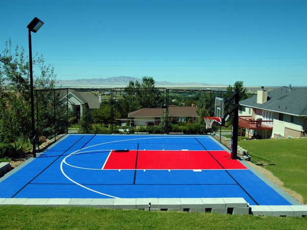 Multi-court in bright blue and red with lights and fencing