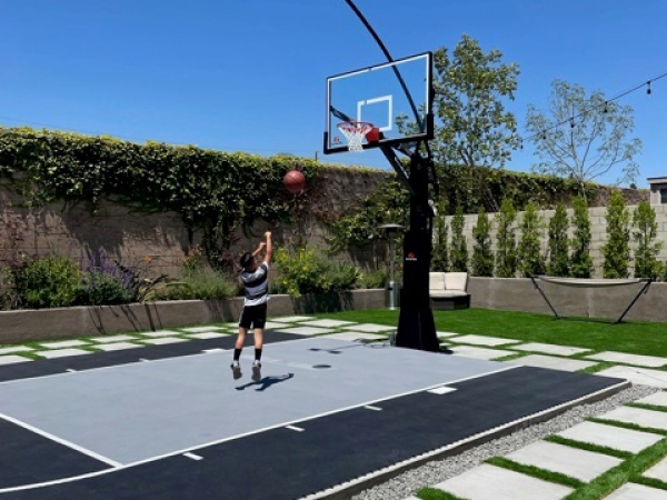 Kid playing on a black and gray court