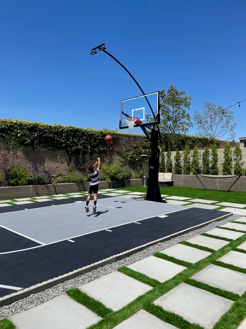 Kid playing on a black and gray court