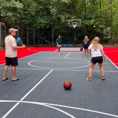 family-playing-pickleball-multi-court-red-graphite