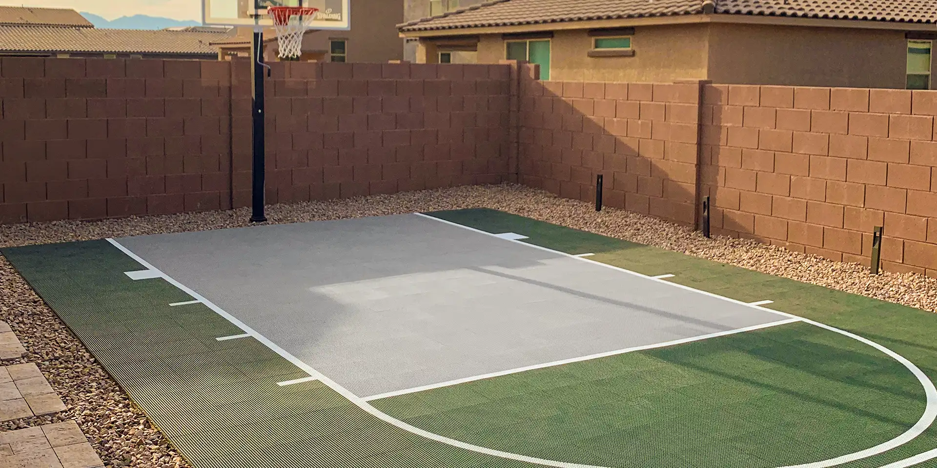A green backyard basketball court with a gray key