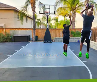 A father and son play basketball on their small backyard court