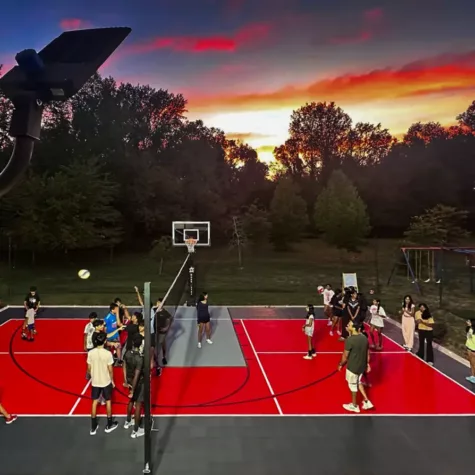 Large extended family plays volleyball into the night on their Dunkstar court