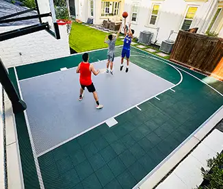 friends shoot some hoops in a backyard with a Dunkstar basketball court