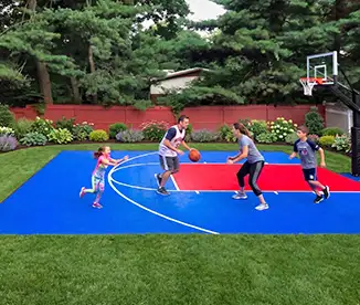 Family of four plays a game of basketball on their Dunkstar backyard basketball court.